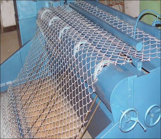 A chain link fence machine in blue color is producing chain link fence