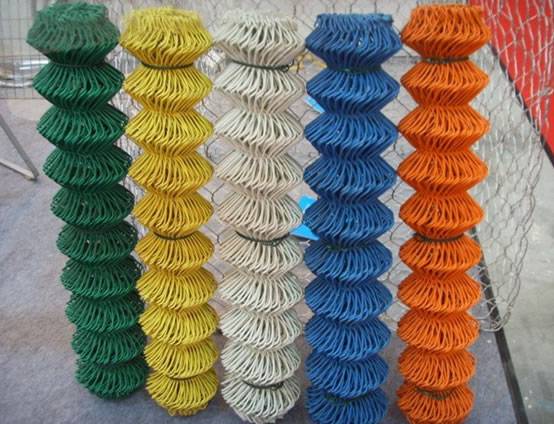 Green, yellow, white, blue and orange PVC coated wire mesh stands on the ground